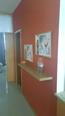 a room with two pictures on a wall with a shelf at My Flat 2 in Praia