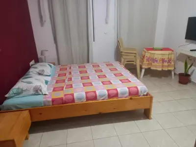 a bedroom with a bed and a table and chairs at SAM House in Mindelo