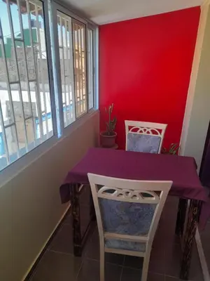 a purple table and chairs in a room with a red wall at SAM House in Mindelo