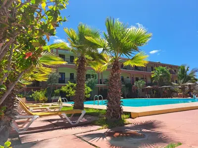 a resort with a swimming pool and palm trees at Bamboo Xaguate Hotel in São Filipe