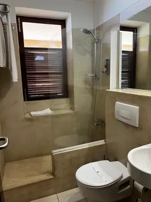 a bathroom with a shower and a toilet and a sink at Bamboo Xaguate Hotel in São Filipe