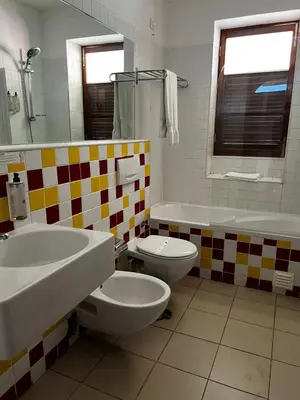 a bathroom with two sinks and a toilet and a tub at Bamboo Xaguate Hotel in São Filipe