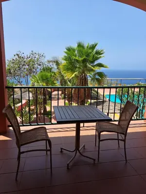 a table and two chairs on a balcony with the ocean at Bamboo Xaguate Hotel in São Filipe