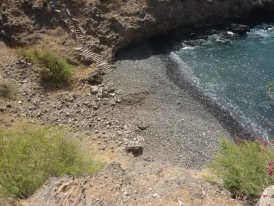 a rocky shore with stairs leading into the water at Villa Halcyon cabo verde close to the beach in Cidade Velha