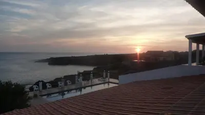a view of the ocean from a balcony with the sunset at Villa Halcyon cabo verde close to the beach in Cidade Velha