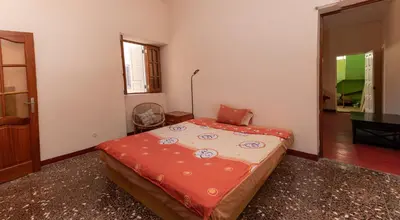 a bedroom with a bed with a red blanket on it at Casa Matnik in Mindelo