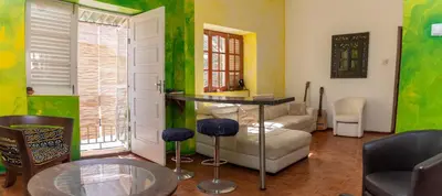 a living room with green walls and a table at Casa Matnik in Mindelo