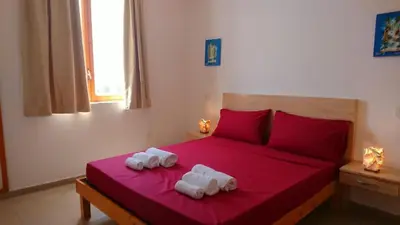 a bedroom with two towels on a red bed at Residence Estrela do Mar in Sal Rei