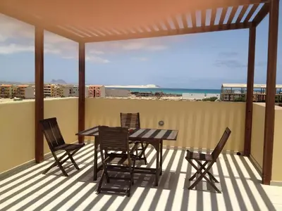 a patio with a table and chairs on a balcony at Residence Estrela do Mar in Sal Rei