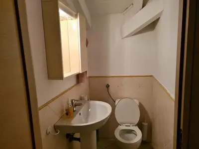 a small bathroom with a toilet and a sink at Plaza Top floor apartment in Santa Maria