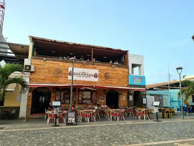 a restaurant with tables and chairs in front of a building at Plaza Top floor apartment in Santa Maria