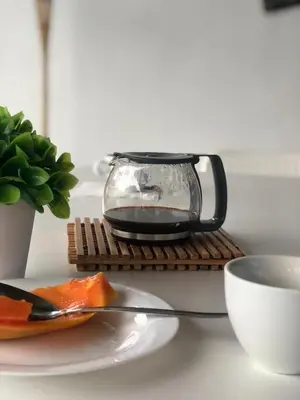 a table with a plate of food and a cup of coffee at Finca Pedra Molar in Órgãos