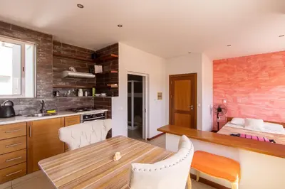 a kitchen and dining room with a wooden table and chairs at Studio Maya Mindelo in Mindelo