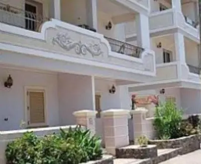 a large white building with two balconies and some plants at Oasis Palmeira in Santa Maria