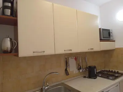 a kitchen with white cabinets and a sink at Oasis Palmeira in Santa Maria