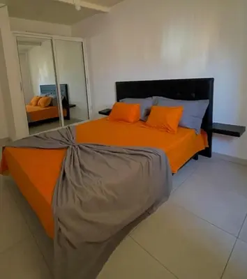 a bedroom with a large orange bed with orange pillows at Apartamento in Praia