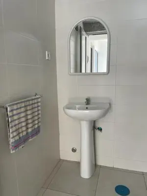 a white bathroom with a sink and a mirror at Apartamento in Praia