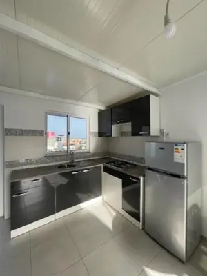 a kitchen with stainless steel appliances and a window at Apartamento in Praia