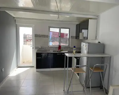 a kitchen with a counter and some chairs in it at Apartamento in Praia