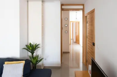 a living room with a blue couch and a door at 2 bdr cozy apt near Praça Center, AC & Fast Wi-Fi in Praia