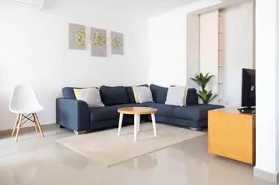 a living room with a blue couch and a table at 2 bdr cozy apt near Praça Center, AC & Fast Wi-Fi in Praia