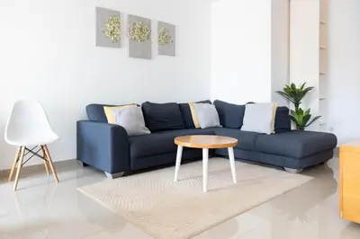 a living room with a blue couch and a table at 2 bdr cozy apt near Praça Center, AC & Fast Wi-Fi in Praia
