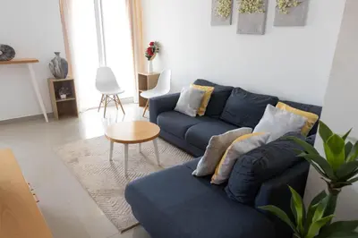 a living room with a blue couch and a table at 2 bdr cozy apt near Praça Center, AC & Fast Wi-Fi in Praia