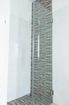 a shower with a glass door in a bathroom at 2 bdr cozy apt near Praça Center, AC & Fast Wi-Fi in Praia