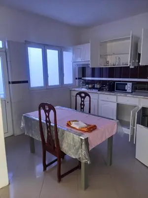 a kitchen with a table and two chairs and a table and a kitchen at CHEZ LU & LUCIO in Assomada