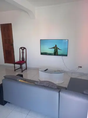 a living room with a couch and a tv on a wall at CHEZ LU & LUCIO in Assomada