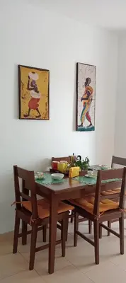 a dining room table with two chairs and a table with food on it at Farfalla in Vila do Maio
