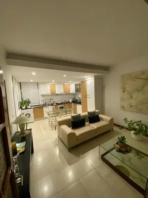 a living room with a couch and a kitchen at Residence Fazenda - Piscina in Praia