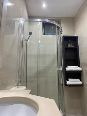 a bathroom with a shower and a toilet and towels at Residence Fazenda - Piscina in Praia