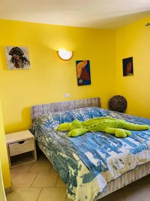a bedroom with a bed with a large green object on it at Holiday Properties Casa Laranja in Santa Maria