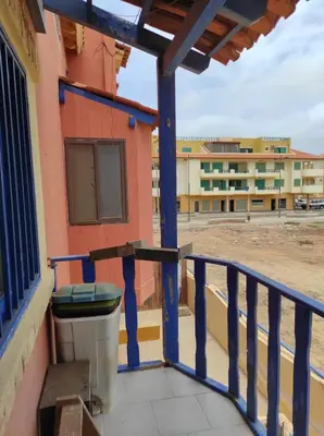 a balcony with a trash can and a building at Holiday Properties Casa Laranja in Santa Maria