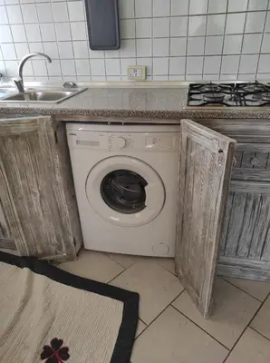 a washing machine in a kitchen with a sink at Holiday Properties Casa Laranja in Santa Maria