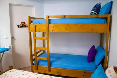 two bunk beds in a room with a ladder at Relaxing Blue Flat near beach! in Calheta Do Maio