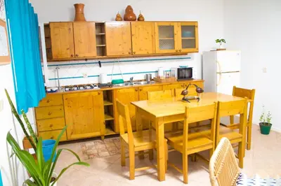 a kitchen with wooden cabinets and a wooden table at Relaxing Blue Flat near beach! in Calheta Do Maio