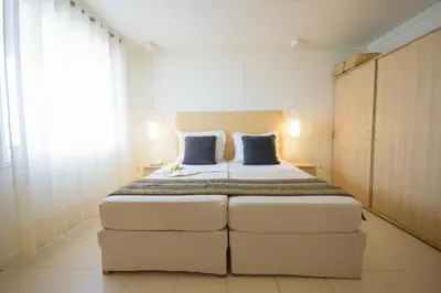 a bedroom with a large white bed with blue pillows at Oasis Belorizonte in Santa Maria