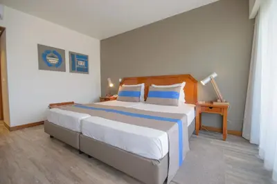 a bedroom with a large bed with blue and white sheets at Oasis Belorizonte in Santa Maria