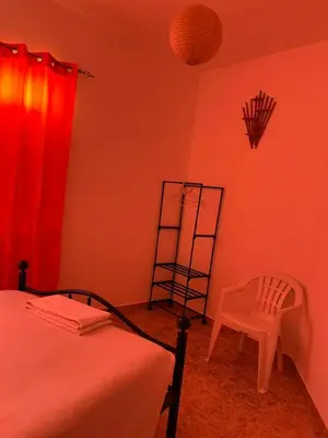 a bedroom with a bed and a ladder and a chair at Tarrafal Ecodécor Rooms in Tarrafal
