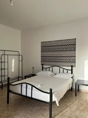 a bedroom with a large bed with a black headboard at Tarrafal Ecodécor Rooms in Tarrafal