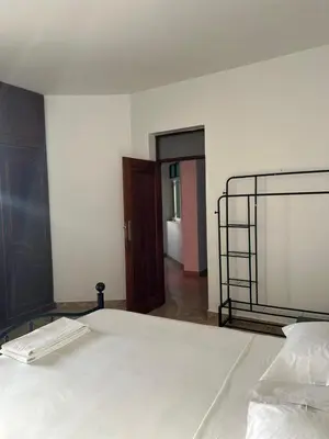 a bedroom with a white bed with a black frame at Tarrafal Ecodécor Rooms in Tarrafal