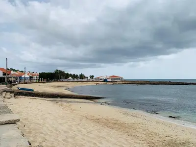 a sandy beach with houses and the ocean at Casa Mar e Sol - Murdeira - Ilha do Sal in Palha Verde