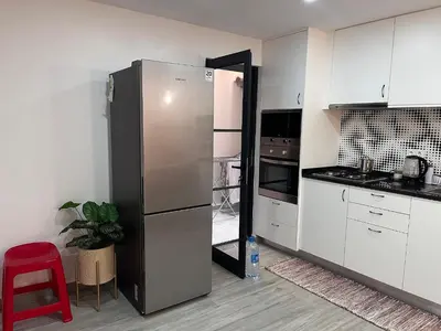 a kitchen with a refrigerator and a red stool at Casa Mar e Sol - Murdeira - Ilha do Sal in Palha Verde