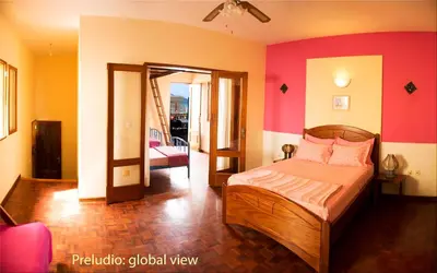 a bedroom with a bed with pink and orange walls at Solar Windelo in Mindelo