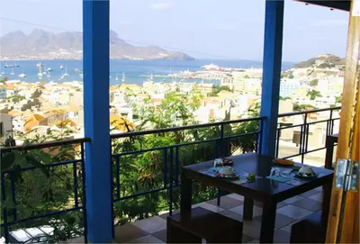 a balcony with a table and a view of the ocean at Solar Windelo in Mindelo