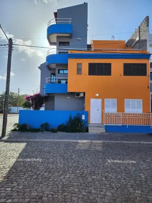 a house with an orange and blue building at Castelinho Sal Lodge in Espargos