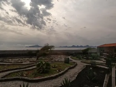 a garden with a view of the water and mountains at Vila Babosa in Porto Novo