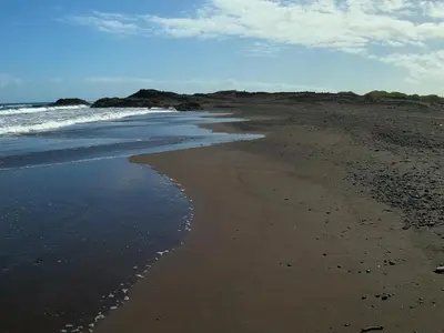 a beach with the ocean and the shoreline at Vila Babosa in Porto Novo